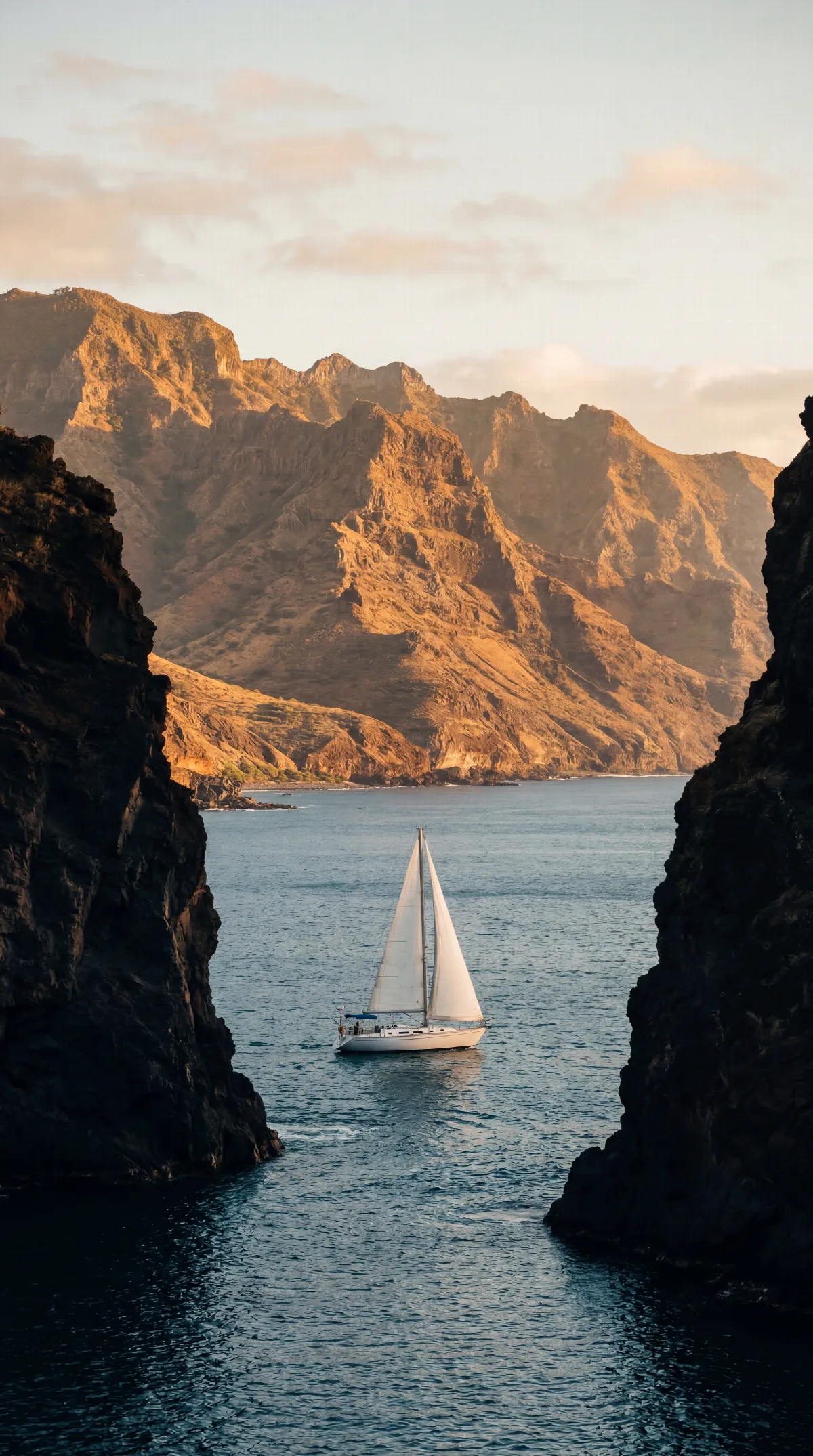 Sailboat Between Volcanic Cliffs